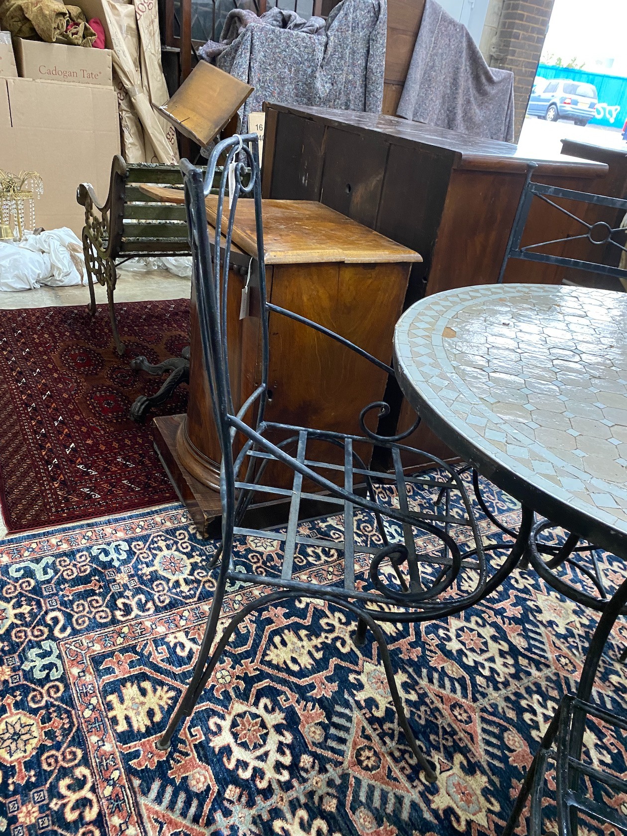 A circular mosaic top wrought iron garden table, diameter 100cm, height 74cm together with four wrought iron garden chairs, two with arms